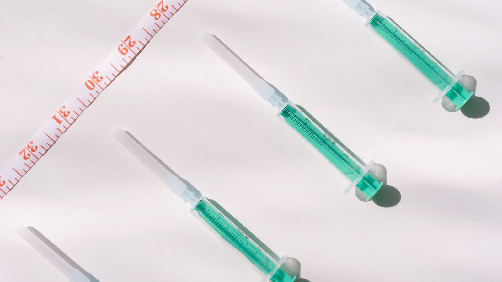 Injection pens and a measuring tape, representing medical weight loss treatment