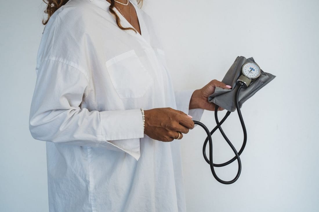 Doctor holding a blood pressure monitor, representing chronic condition management